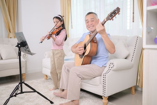 A girl violinist and her grandfather practice music together at home photo