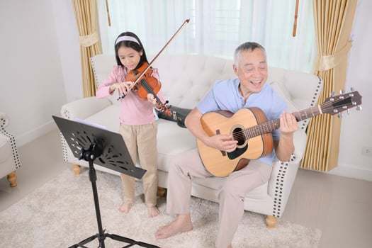 A girl violinist and her grandfather practice music together at home photo