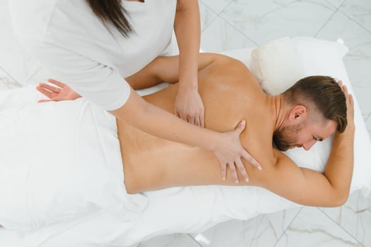 Handsome middle-aged man enjoying relaxing spa massage with oils photo