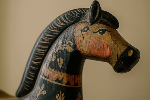 A beautifully crafted wooden horse sculpture features detailed decorations in vibrant colors. The subject is prominently displayed against a simple background, highlighting its artistry. photo
