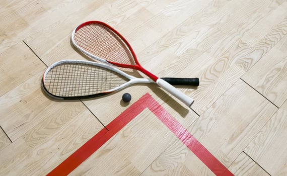 Squash rackets and ball on court floor, top view photo