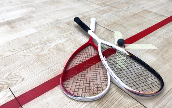 Squash Rackets And a Ball on a Wooden Court Floor. Sport Theme. photo