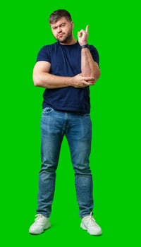 A man thoughtfully ponders on a bright green background photo