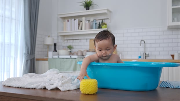 When parents gives the baby a bath, he enjoys it photo