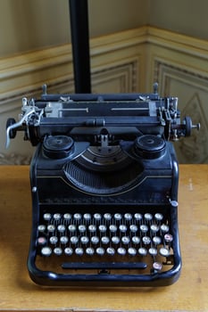 An old fashioned typewriter sits on a wooden table photo