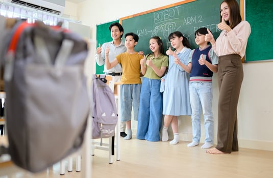 Portrait of a teacher and kids in a classroom where children have pleasure learning photo