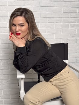 blonde fashion model in pastel beige suit sitting on chair photo