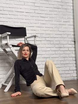 blonde fashion model in pastel beige suit sitting on chair photo