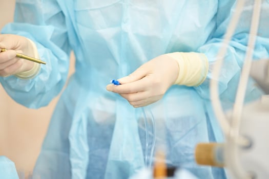 Healthcare professional in medical scrubs prepares equipment for surgical procedure in a sterile environment photo