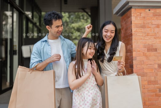 Happy Family Enjoying Shopping Together with Credit Card in Modern Urban Setting photo