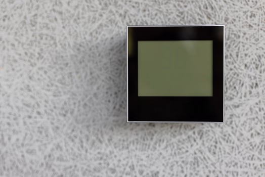 The air conditioning and heating control panel for the apartment and office is located on a white wall. photo