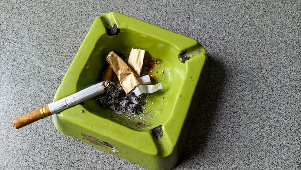 Close up of a green ashtray and a cigarette. photo