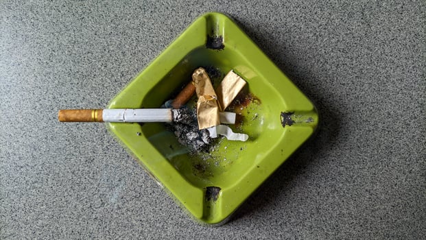 Close up of a green ashtray and a cigarette. photo