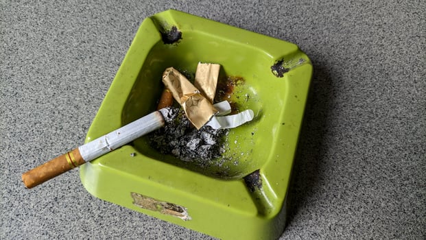 Close up of a green ashtray and a cigarette. photo