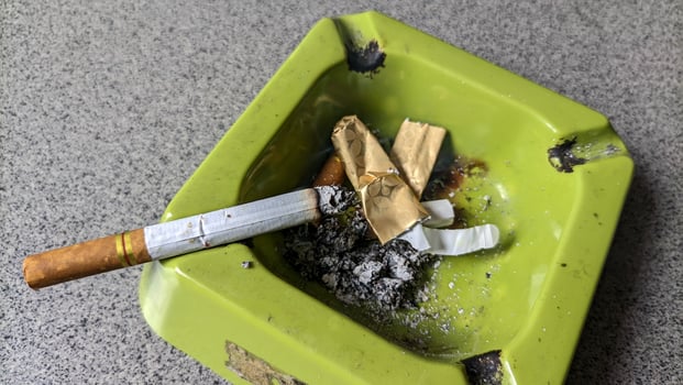 Close up of a green ashtray and a cigarette. photo