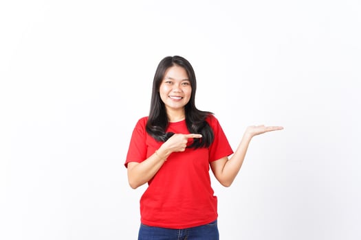 Smiling presenting and pointing at open palm for advertising Of Beautiful Asian Woman Wearing Red Shirt Isolated On White Background photo