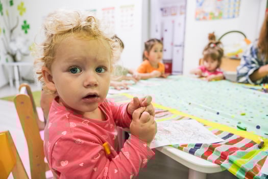 Beautiful blonde baby girl playing in kindergarten photo