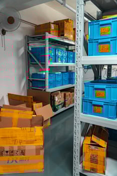 An Organized Storage Area featuring numerous Blue Plastic Bins for various items and materials photo