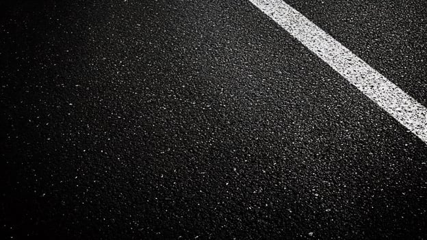 Black and white photo of a road with white lines