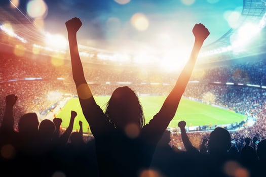 Silhouette of a woman with her arms raised in front of a soccer stadium photo