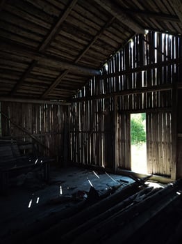 Light shining through gaps in the wall of an old barn photo