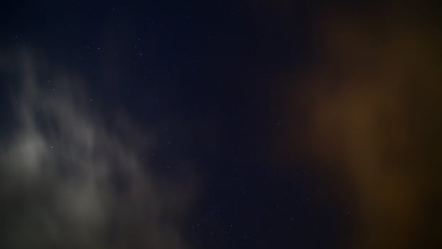 Long exposure of moving clouds on starry sky photo