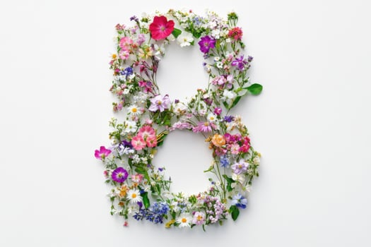 Floral arrangement of the letter B created with various colorful flowers on a white background photo