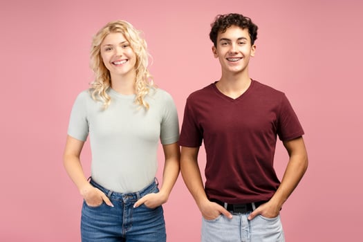 Portrait of smiling, happy teen boy and girl, friends holding hands in pocket, looking at camera photo
