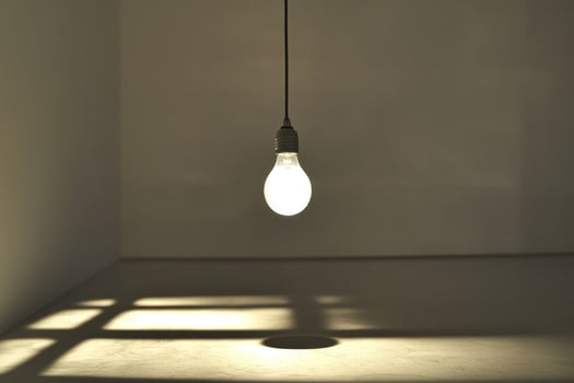 A Single Lightbulb Hanging and Casting Shadows on a White Floor photo