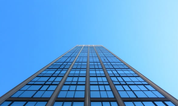 A tall modern building reaching towards a clear blue sky. photo