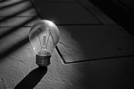 A Single Light Bulb on a Concrete Surface in Black and White photo