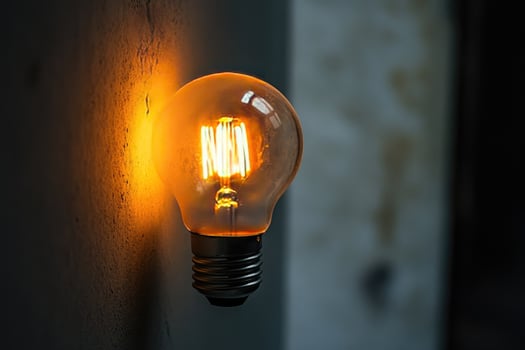 A Glowing Light Bulb Against a Textured Wall photo