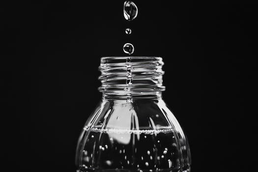 Water Droplets Falling Into a Water Bottle photo