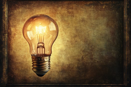 Illuminated Vintage Light Bulb Against Grungy Canvas Background photo