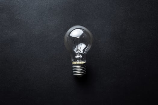 A Single Light Bulb on a Dark Background photo