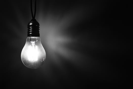 A Single Lightbulb Hanging in a Dark Room photo
