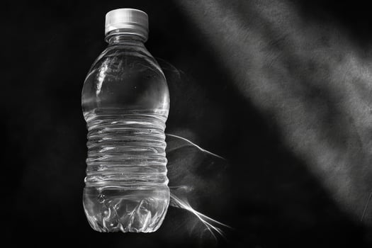 A Single Plastic Water Bottle on a Black Surface photo