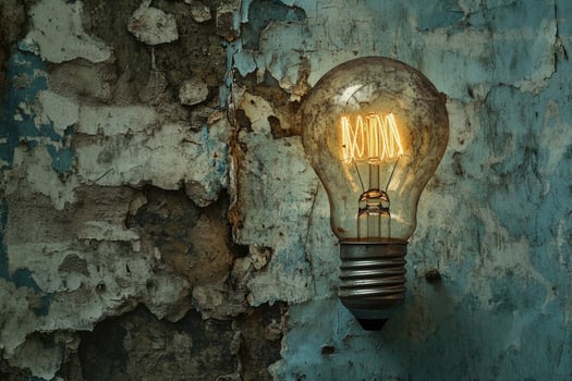 An Old Light Bulb Against a Weathered Wall photo
