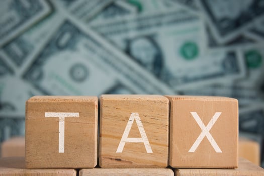 Wooden Blocks Spelling Tax with US Dollar Background photo
