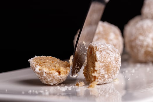 Beautiful sweets with coconut on a white plate on a black background photo