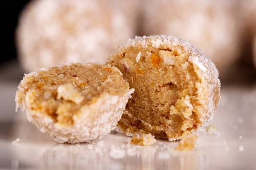 Beautiful sweets with coconut on a white plate on a black background photo
