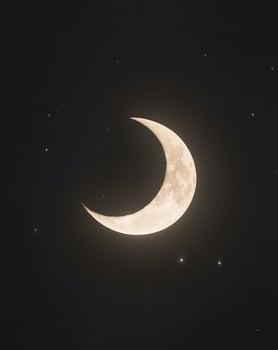 A crescent moon is shown in the night sky photo