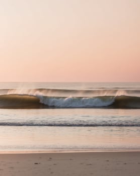 Serene Ocean Waves Crashing on Sandy Beach at Golden Sunset photo