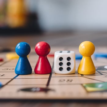 Three colorful game pieces and dice on board, focused interaction, blurred background For Social Media Post Size photo