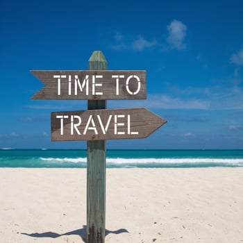 Wooden signpost on beach reads TIME TO TRAVEL, ocean and sky behind For Social Media Post Size photo