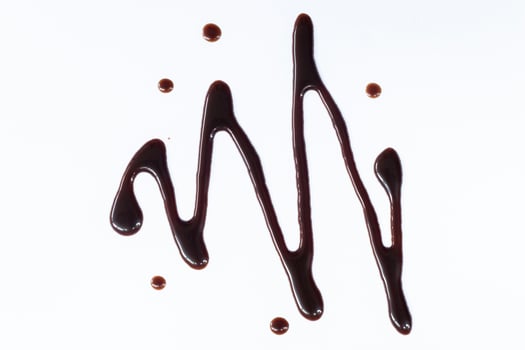 Chocolate syrup drizzle isolated on white background. A splash of sweet chocolate sauce. Top view. photo