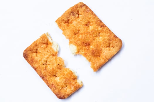 Broken stem ginger biscuits with crumbs isolated on white. Top view. photo