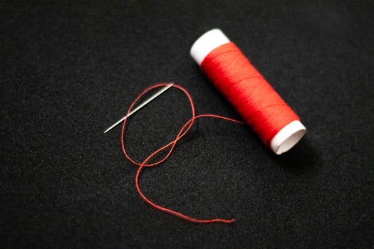 spool of thread with a needle on black isolated background photo