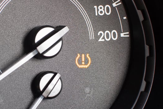 Tire pressure warning light on car dashboard , Automotive repair concept photo
