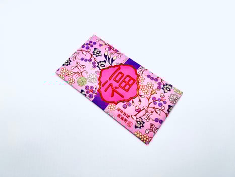 A vibrant red envelope or angpao or angpau or red packet used for gifting money during celebrations with gold floral patterns and a Chinese character for good fortune or prosperity photo